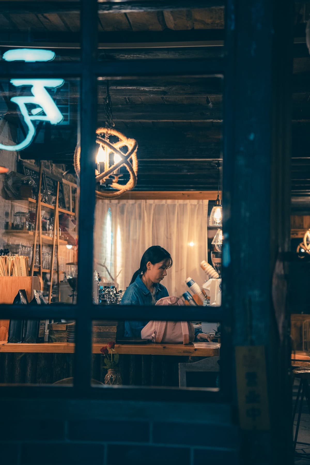 Person working at a desk, seen through a window